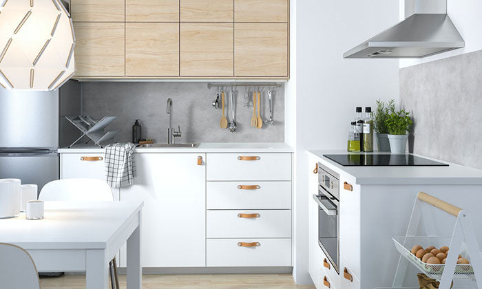 Aurora Interior Design 打造了一個白色廚房，配有木桌和椅子。